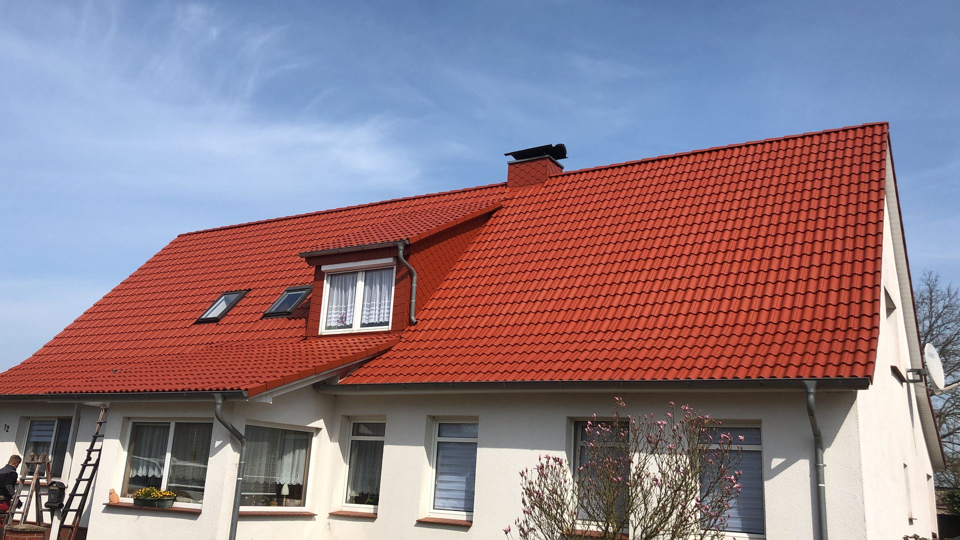 Einfamilienhaus mit frisch rot beschichtetem Dach