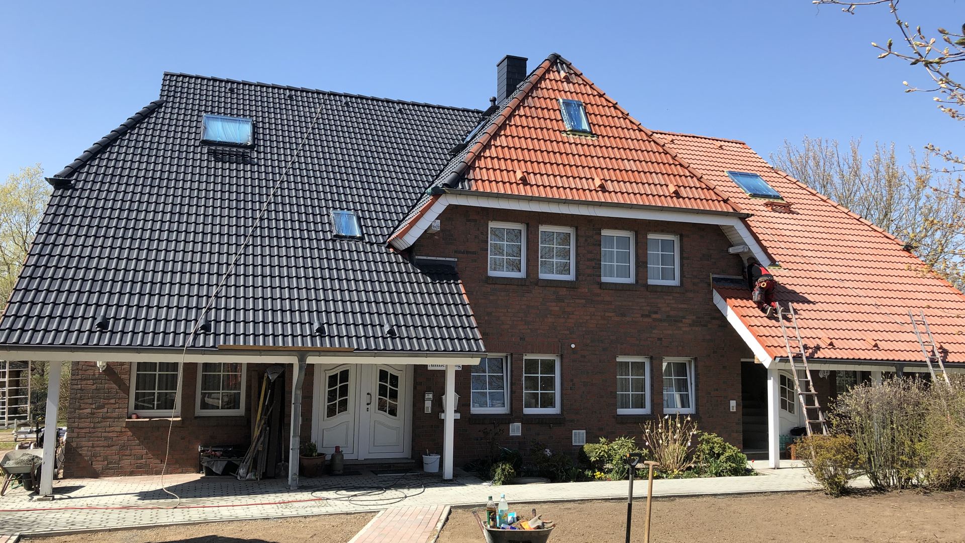 Doppelhaus mit zwei Dachfarben, links Anthrazit, rechts Rot